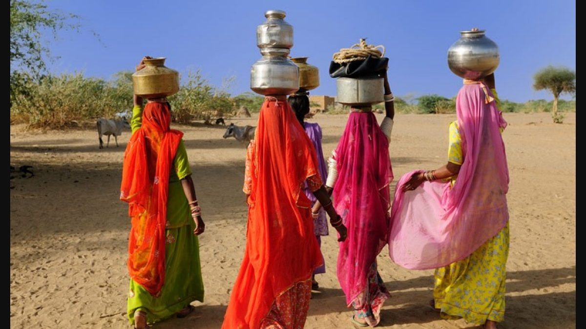 women carrying jugs of water on their backs.